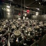 Interior view of a large underground neutrino detector filled with suspended photomultiplier tubes used to detect rare particle interactions.